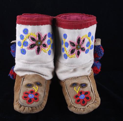 Athabascan Beaded Moccasin Boots Mid-1900: Included in this lot are a pair of Athabascan Native American beaded high top moccasins from the mid 1900s. Intricate bead work depicts a floral design of periwinkle blue, Cheyenne pink, pumpkin yello