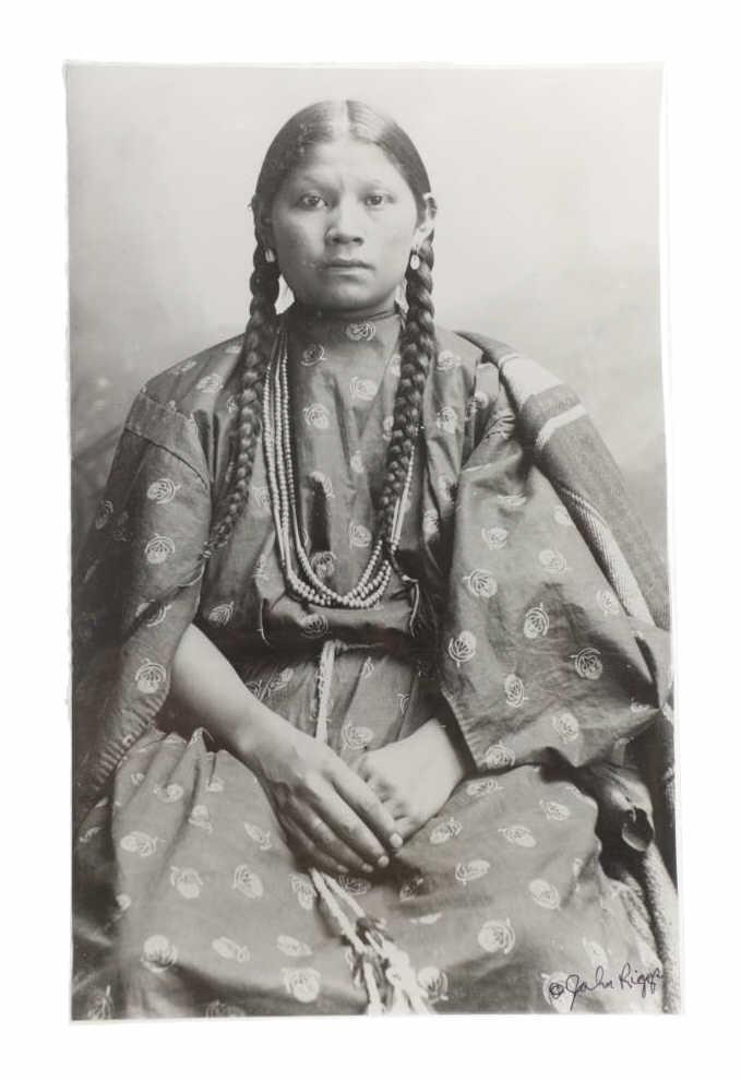 C. 1800's Montana Plains Indian Original Photo: Included in this lot we have a Native American Indian woman original signed silver gelatin photograph by John Riggs originating from the late 1800's. The photo depicts a young Indian woman sitting wea