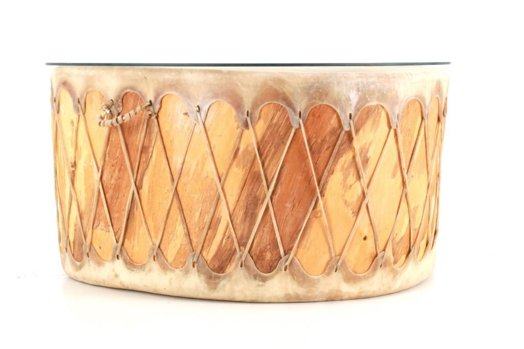 Taos Drum One Log Carved Wooden Coffee Table: Featured in this lot is this Taos drum one log carved wooden coffee table. The table features a cut glass top that protects the wonderfully crafted Taos drum. The drum features a double sided stretche
