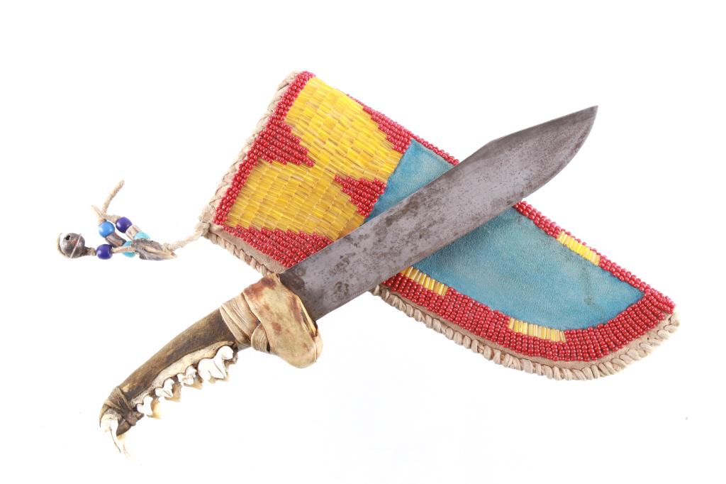 Plateau Beaded Sheath & Wolf Jaw Trade Knife 20th: The lot features a Plateau Indian beaded sheath and Wolf jaw trade knife from the 20th Century. The knife shows an older trade knife clip point bowie like blade which is secured to the handle rawhide