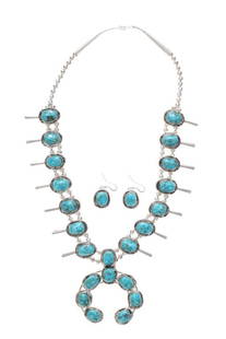 Navajo Blue Gem Turquoise Squash Blossom Set: The lot features a beautiful sterling silver and turquoise squash blossom necklace and earring set that is signed by a Navajo artist. The pair is set with beautiful polished cabochons stones from the