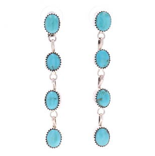 Navajo Cripple Creek Turquoise Dangle Earrings: The lot features a set of dangle earrings in sterling silver set with Cripple Creek Turquoise from a Navajo artist. These show four dangling stones each in sterling silver with eight total polished