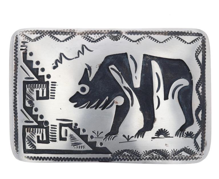 Navajo Nickel Silver Bear Belt Buckle - T.A. Begay: The lot features a nickel silver belt buckle signed by T.A. Begay showing a shadowbox bear adn stamped design. The buckle shows the A BEGAY and crossed arrows with NICKEL hallmark. The piece measures 