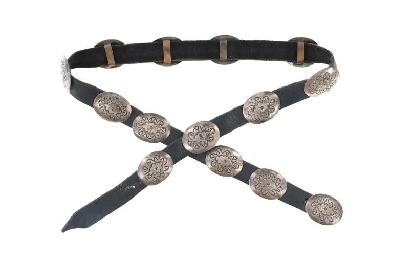 Navajo Native American Sterling Concho Belt 1950s: Featured in this lot is this Native American Navajo sterling and leather concho belt circa 1950s. The belt showcases fourteen sterling conchos showing a nice, geometric design on each. They are connec