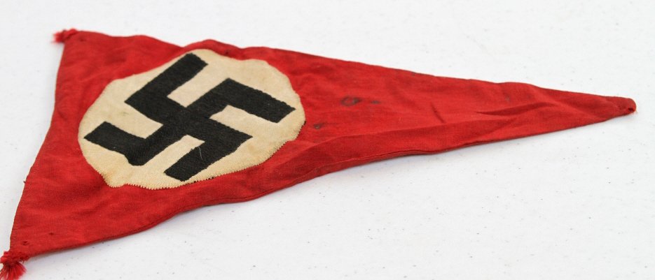 Nazi Pennant: This piece is a triagle shaped orignal WWII Nazi Pennant. Red with a Black Sawastika on a white background, and is double sided. Measures 6" wide at the top and 9" long.