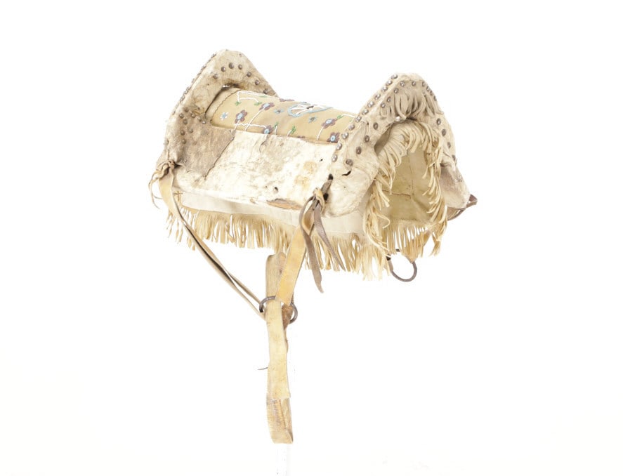 19th C. Northern Cheyenne Rawhide Saddle: The lot features a 19th-century Northern Cheyenne parfleche rawhide saddle that is tacked and accompanied by a beaded saddle pad with whimisical beadwork and is from a former March in Montana sale. Th