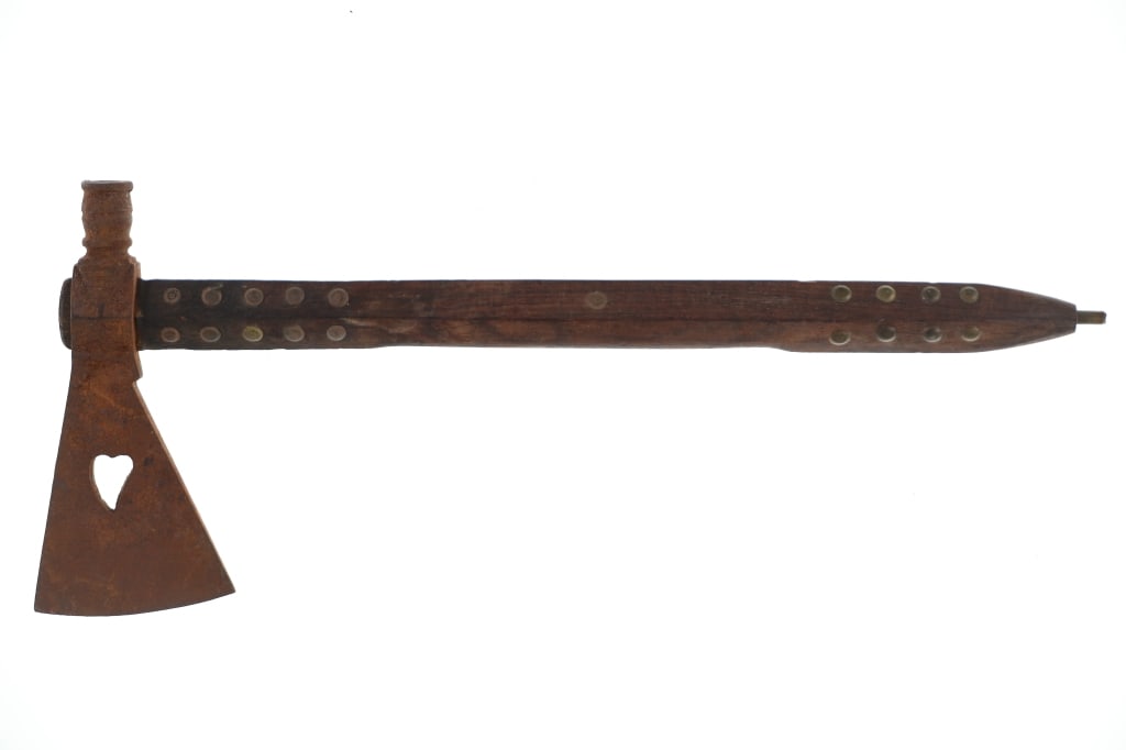 1920-1950's Trade Weeping Heart Pipe Tomahawk: The lot features a forged iron tomahawk with weeping heart cutout at the center, from 1920-1950's. The head shows signs of being blacksmith forged having a hammered irregular surface. The tomahawk hea