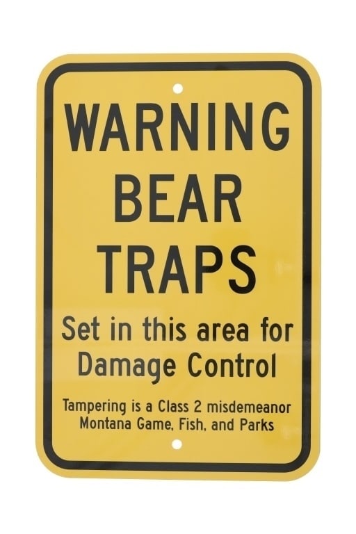 Warning Bear Trap Montana Game, Fish, & Parks Sign: Featured in this lot is a Warning Bear Traps Montana Game, Fish, and Parks sign. The sign features a wonderfully and professionally crafted metal construction that shows a yellow field with black lett