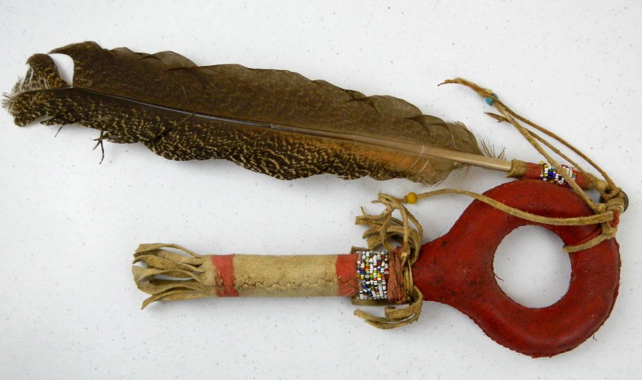 Lakota Sioux Rattle circa 1880's: This is made with Buffalo Rawhide and sewn with Elk Sinew. Has trade paints, willow wood grip, "Crazy Beads" Venice Trade Beads from 1870's, and has a Turkey Feather. The Rattle is full and has good s