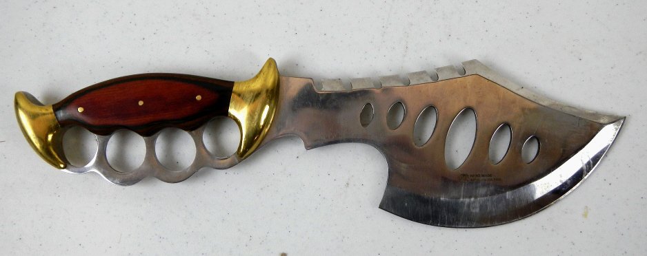 Brass Knuckles Fighting Knife: This is a unique piece that is "Hand Made 440 Stainless Steel (with a rose image)." The Knife is a combination of Brass Knuckles with brass ands and rose wood, and also a butcher type blade. This mass