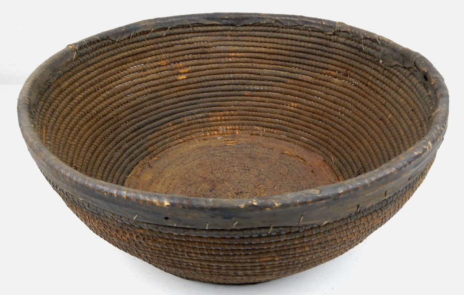 Northern Plains Indian Basket: This piece was made by the Northern Plains Native Americans. This is all hand woven and has a leather edge and a leather or rawhide bottom. This date pre-1900' and is in good condition with great pati