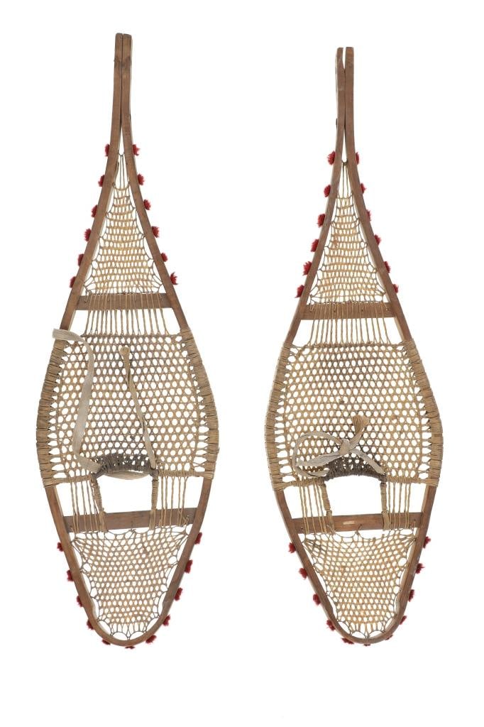 Ca. 1910 Ojibwa Rawhide Snowshoes: The lot features a set of rawhide and wood snowshoes with red plume adornments from the Ojibwa people of the Great Lakes Huron region. The set is dated to circa 1910 and show a classic snow show shape