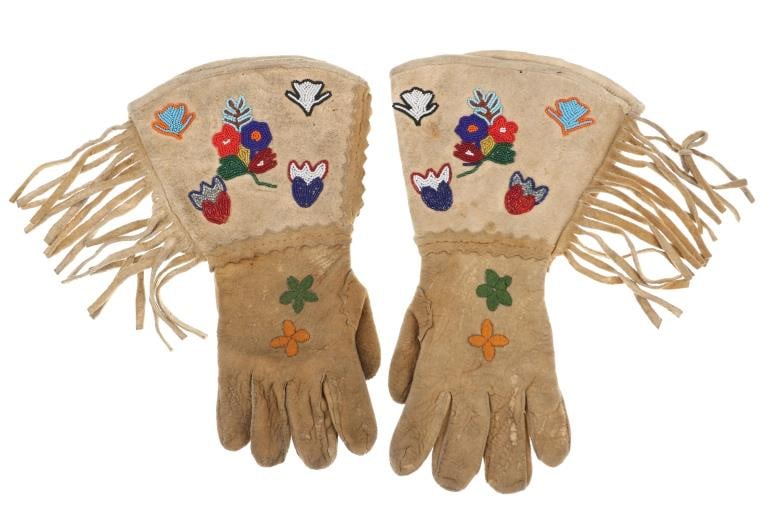 Ca. 1930's Crow Apsaalooke Beaded Gauntlet Gloves: The lot features a nice set of Indian tanned hide gloves with whimsical beadwork and embroidery from the circa 1930's Crow Apsaalooke of Montana. The set exhibits Indian tanned hide with nice thick In
