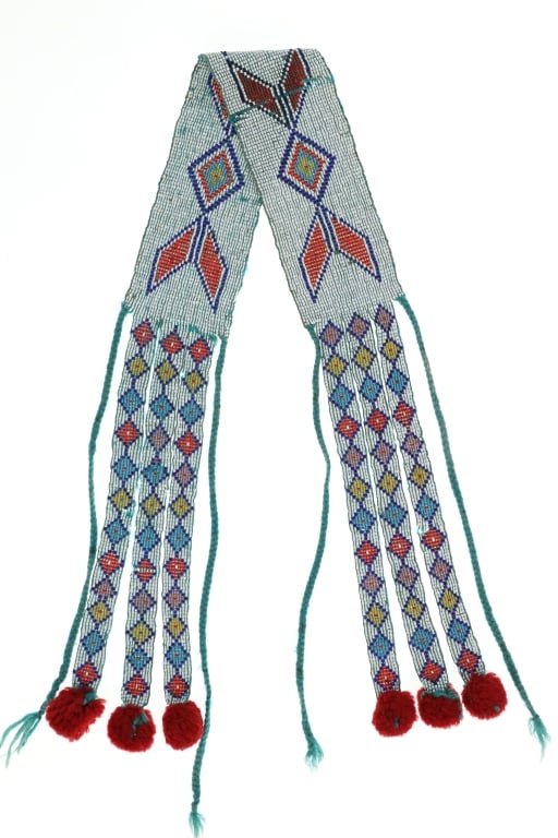 Ca. 1930's Anishinaabe Loom Beaded Sash: The lot features a circa 1930's Anishinaabe Loom Beaded Sash. The sash shows a green yarn interwoven into the cotton thread sewn loom-beading with pony glass trade beads with a geometric diamond patte