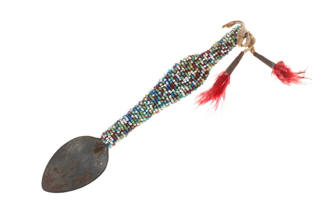 Ca. 1910-1920's Crow Beaded Metal Spoon: This is a circa 1910-1920's Crow beaded hide wrapped metal spoon. The piece shows a metal spoon at the center which has been wrapped in Indian tanned buckskin with thread sewing and is covered in thre