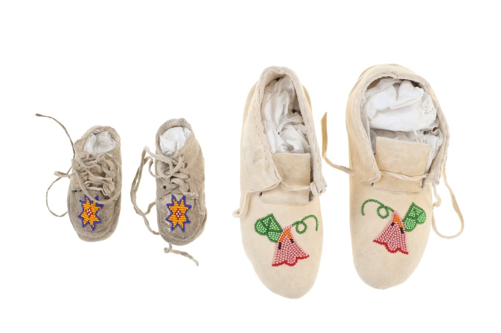 Vintage Montana Crow Beaded Moccasin Sets (2): The lot features two sets of Vintage Montana Crow beaded Indian hide moccasins. Both are comprised of Indian tanned hide with glass trade seed beads beadwork in a floral or geometric design. The one s