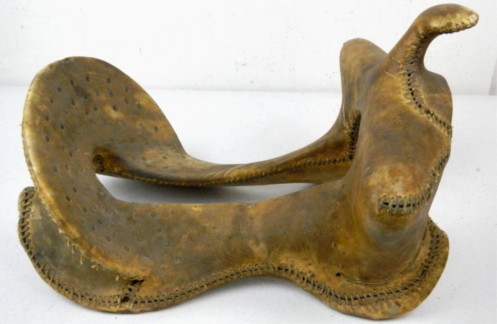 Antique Rawhide wrapped Saddle Tree: This piece is entirely wrapped in rawhide and rawhide sewn. Has a great decor look. Thought to have been owned by Sioux Native Americans. Early 1900's lte 1800's piece. Measures overall 18" long.