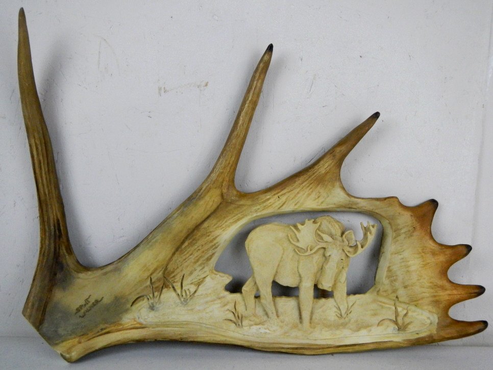 "Spirit Walker" by Big Sky Carvers: This lot is made by Big Sky Carvers of Manhattan Montana and features a Moose antler Casting with carved moose figure and is signed, "Spirit Walker." The antler is a casting and comes with the origina