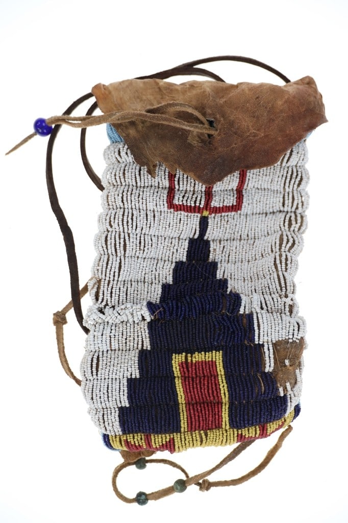 Ca. 1870 Lakota Sioux Tobacco Beaded Hide Bag: The lot features a fantastic circa 1870's Lakota Sioux beaded tobacco bag from a fantastic Montana collection. The bag exhibits Indian tanned hide, which has stiffened with age, sewn with sinew and co