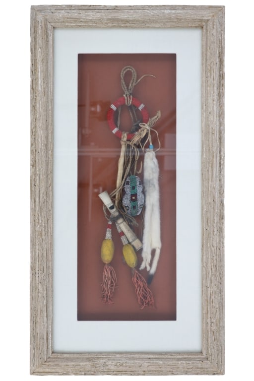 Northern Plains Whistle Beaded Medicine Bundle: The lot features a Northern Plains beaded medicine bundle with carved bone whistle that has been beautifully framed. The piece exhibits Indian tanned hide braided ties holding onto a fully beaded medi