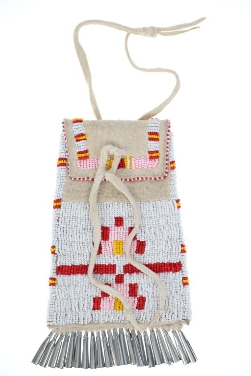 Northern Plains Beaded Hide Strike-A-Lite Bag: The lot features an Indian hide beaded strike-a-lite bag from the Northern Plains from the mid-to-late 20th century. The bag exhibits Indian tanned hide covered in glass trade seed beads with a sinew