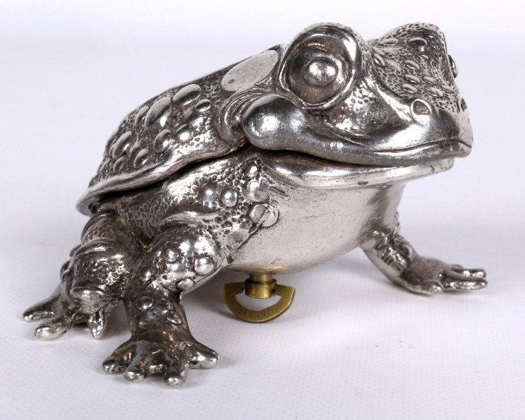 Reed & Barton Frog Music Box: This piece is a Silver toned music box in working condition that is in a detailed design of a frog. The piece when wound plays the "Twinkle, Twinkle Little Star" song. This is in fantastic condition.