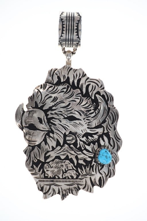Navajo R. Singer Sterling Silver Buffalo Pendant: Featured in this sterling silver and turquoise buffalo pendant from Navajo artist R. Singer. The pendant features a wonderfully and professionally crafted sterling silver in a buffalo design that show
