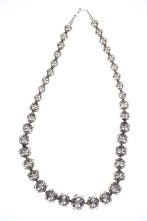 Old Pawn Navajo Graduated Bench Bead Necklace: Featured in this lot is this Navajo graduated sterling silver bench bead necklace. The necklace features a wonderfully and professionally crafted sterling silver with graduated bench beads and