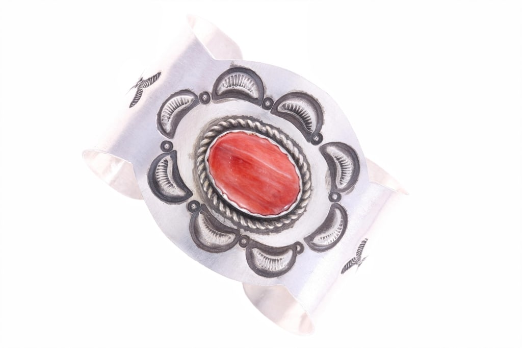 Classic Navajo Repousse & Stamped Bracelet -Signed: The lot feautures a classic repousse and old stamped sterling silver Navajo bracelet with late 20th-to-21st-century age, signed by Chaz Tsosie. The bracelet features a wonderfully and professionally