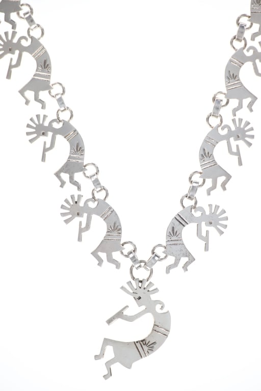 Navajo Din? Dancing Kokopelli Sterling Necklace: Presented in this lot is a Vintage Navajo Sterling Silver Dancing Kokopelli Necklace, circa late century. The necklace features eleven (11) dancing kokopellis on a silver link chain. The Kokopelli