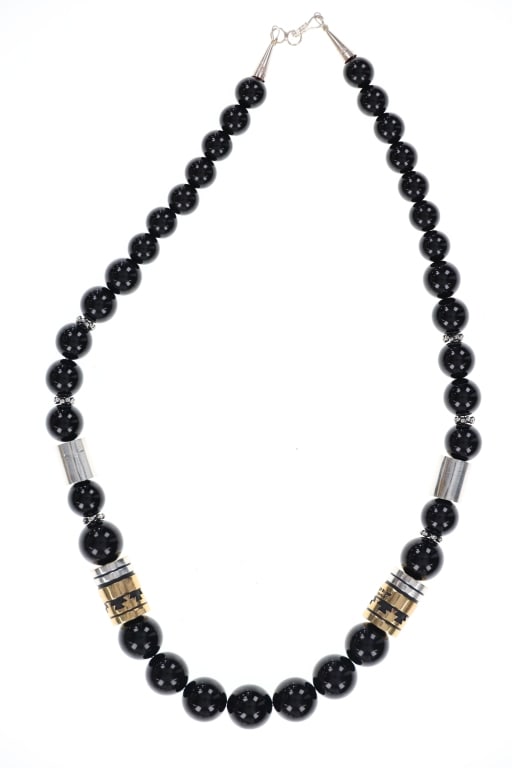Navajo Singer Sterling Silver 14kGF & Jet Necklace: Featured in this lot is this sterling silver 14k GF Barrel Bead and jet necklace from Navajo artist Tommy and Rose Singer. The necklace features a wonderfully and professionally crafted jet, sterling 