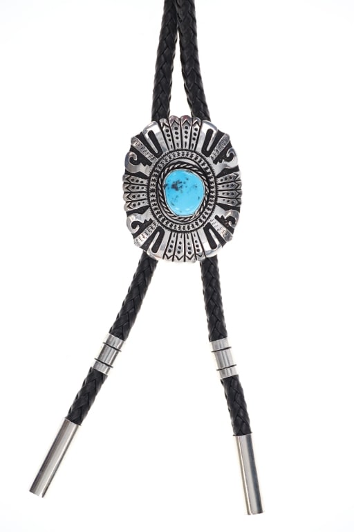 Navajo Singer Sterling Silver & Turquoise Bolo Tie: Featured in this lot is this sterling silver and Sleeping Beauty Turquoise bolo tie from Navajo artists Tommy and Rose Singer. The bolo tie features a wonderfully and professionally crafted sterling s