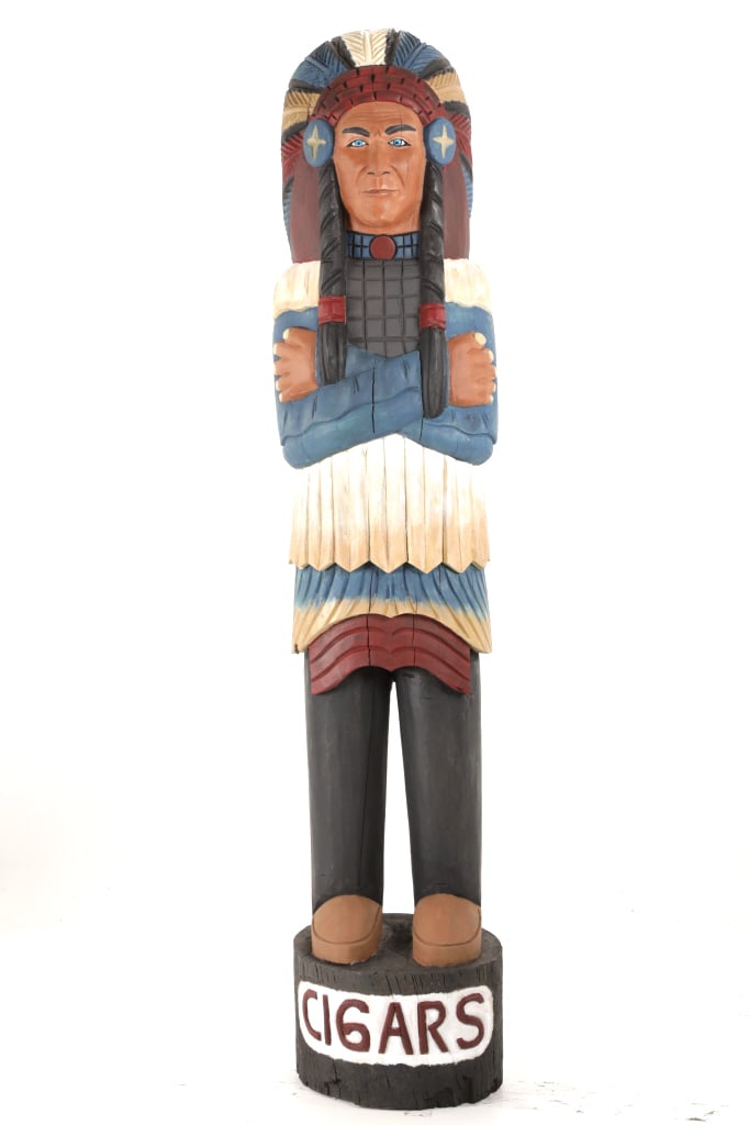 c1930's Solid Wood Carved Cigar Store Indian Chief: The lot features an exceptional early hand carved solid wood American Cigar Store Indian Chief folk art sculpture of a large size dating to circa 1930-1940. The piece is an American carving and shows 
