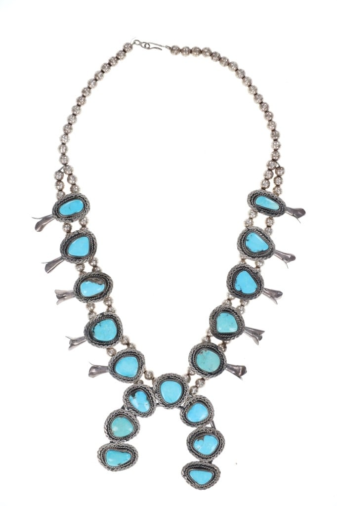 Navajo Kingman Turquoise Squash Blossom Necklace: Featured in this lot is this Navajo Kingman Turquoise squash blossom necklace circa 1960's. The necklace features a wonderfully and professionally crafted sterling silver and Kingman Turquoise constru
