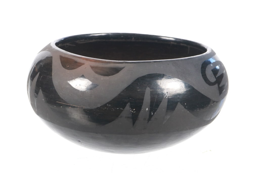 Santa Clara Pueblo Black on Black Bowl c. 1950s: Featured in this lot is this Santa Clara Pueblo black on black bowl circa 1950's. The bowl features a wonderfully and professionally crafted ceramic construction that shows a traditional black on blac