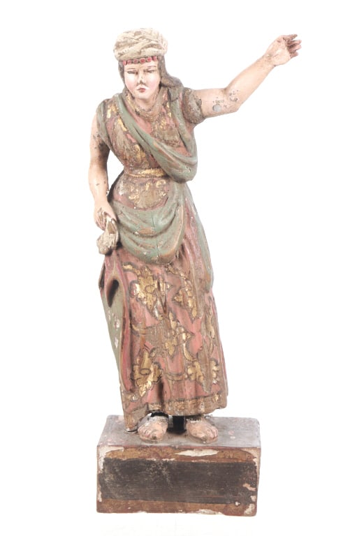 Antique Spanish Colonial Handcarved Santo, 19th C.: Presented in this lot is an Antique Spanish Colonial Handcarved Wood Folk Art Santo, circa 19th century. The Santo is displayed standing with her left arm extended while clutching a bag with her right