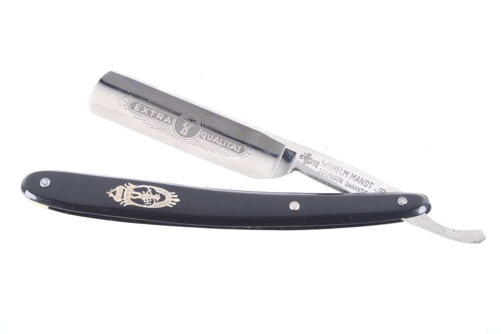Wilhelm Mandt Solingen 5/8 Straight Razor 1940-50s: For your consideration is this Wilhelm Mandt, 5/8 straight razor made in Solingen, Germany in the 1940-50s. This straight razor features a black celluloid handle with inlaid metal logo reading,