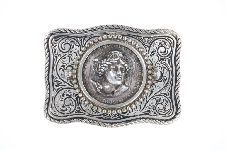Sterling, Nickel Silver & Morgan Dollar Buckle: Featured in this lot is this sterling & nickel silver belt buckle set with a carved and sculpted 1883 Morgan Silver Dollar. This unmarked belt buckle features a sterling and nickel silver construction