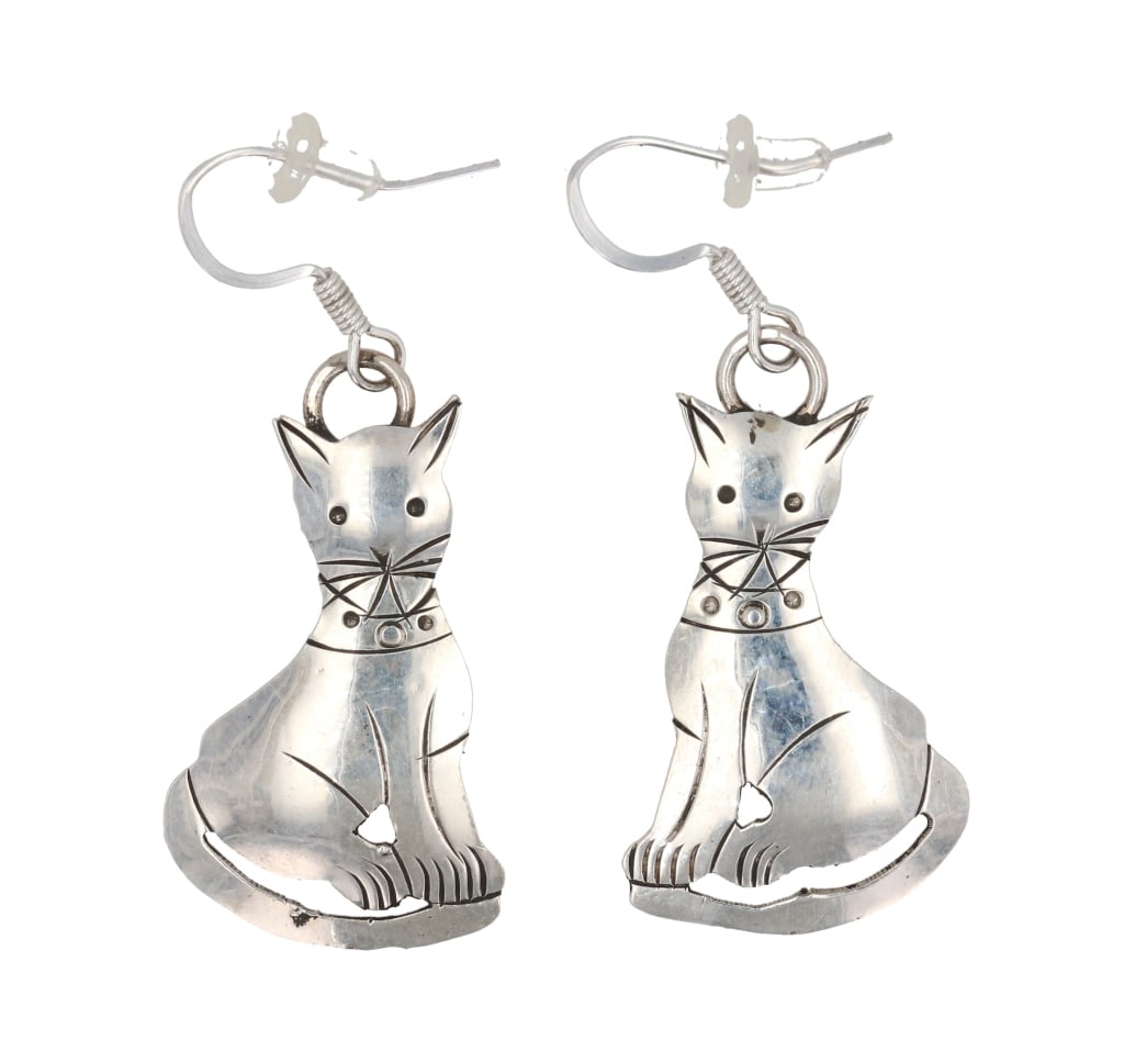 Navajo L. Yazzie Sterling Silver Feline Earrings: Featured in this lot is this sterling silver feline or cat earrings from Navajo artist Lucinda Yazzie. The earrings feature a wonderfully and professionally crafted sterling silver construction and sh