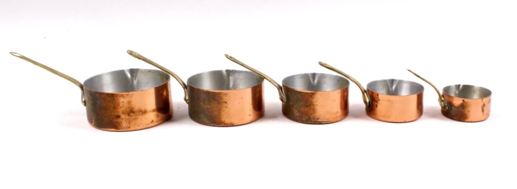 Antique Copper Measuring Cups: Five antique copper measuring cups (complete set) featuring hammered bottoms. Handles include holes for easy hanging for display or use.Largest piece measures 11/2 inches tall by 3 1/2 inches in diame
