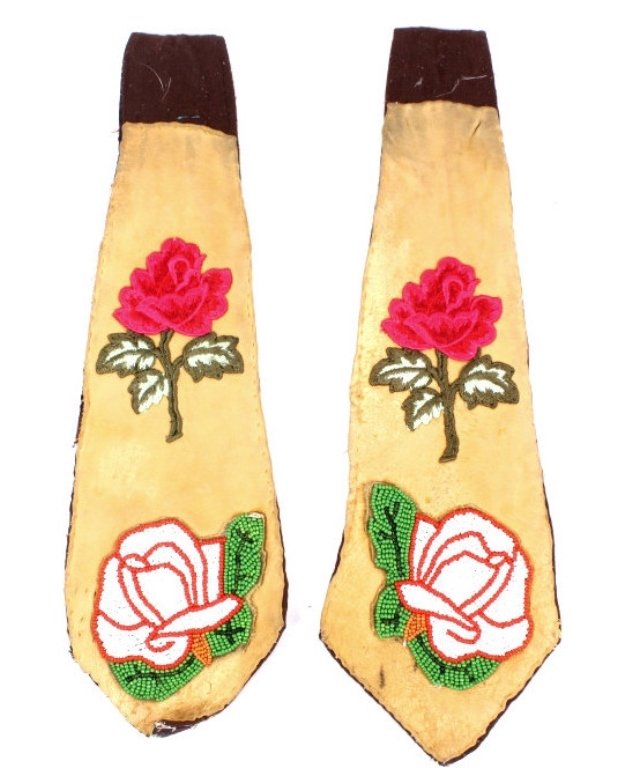 Crow Rose Beaded and Sewn Belt Decorations: This lot features a set of belt decorations that was tightly hand knotted by a Crow Native American. his features two neck tie shaped pieces with old calico and hide fronts showing a pony beaded rose