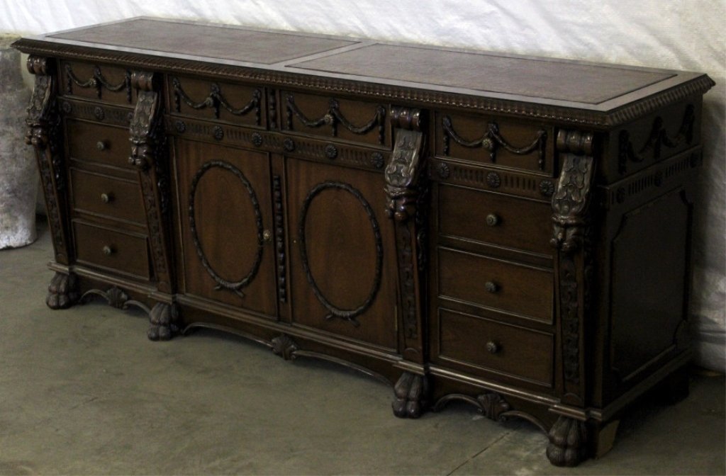 Carved Wood and Leather Sideboard: This piece matches the partners desk and is a very well crafted sideboard. The sideboard is a very well crafted piece showing carved lions heads and lions paw feet. This piece has a leather top with g