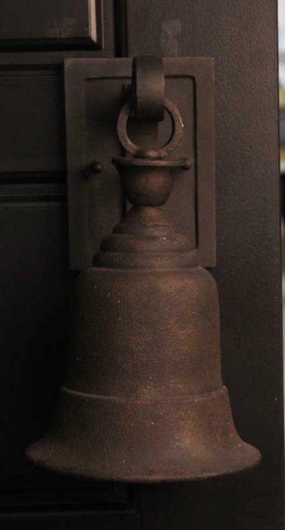 Troy Bell Light Fixture: The light has the shape and patina of an antique bell. This is a designer light made by Troy and is brand new. Measures 1175" tall and 7.5" off the wall.