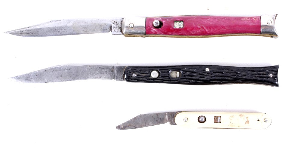Schrade Edgemaster Shur Snap Fishtail Switchblades: This lot features three knives including: 1940's Shur Snap Fishtail Push Button Switchblade not working, Black Schrade Fishtail Push Button Switchblade not working, and white Edgemaster Push Button Sw