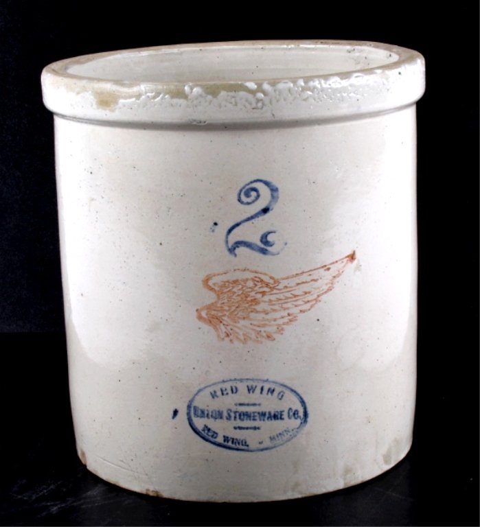 Red Wing 2 Gallon Crock: This lot features a 2 gallon Red Wing crock. It has several chips along the top and bottom. There are no visible cracks. The crock measures 9.5" in diameter and is 10" tall.