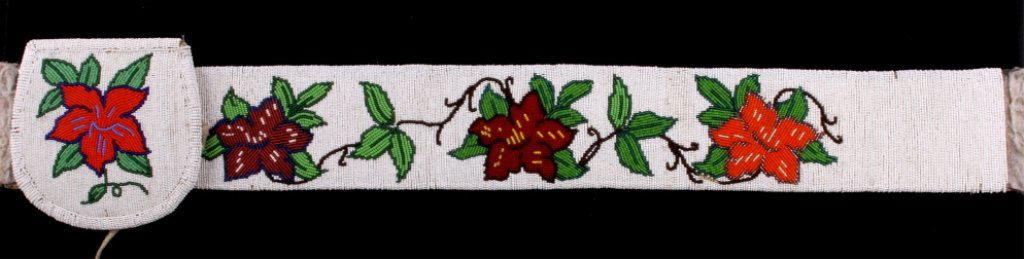 Crow Floral Beaded Belt circa 1930-1940's: The lot features a tightly hand beaded Crow Native American Indian belt. The piece shows original 1800's glass seed trade beads showing a white base with a beautiful floral design. The belt shows exce