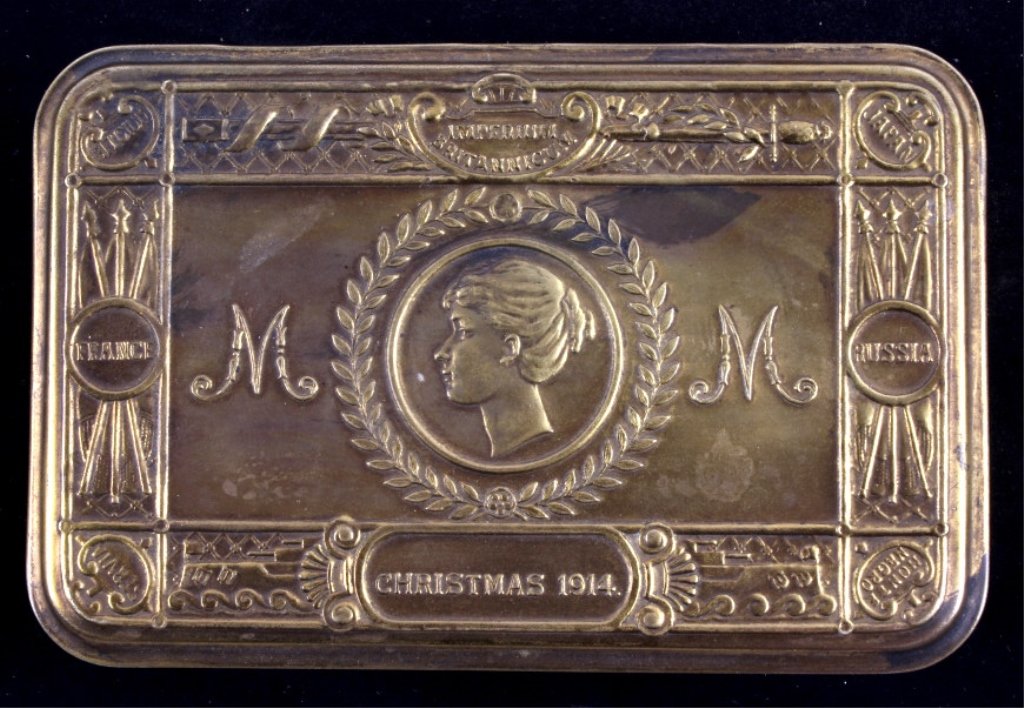 WWI Queen Mary Brass Tobacco Tin This lot features: This lot features a tobacco tin from 1914. These tins were given out to troops in WWI. Often, they were packed with gifts such as cigarettes, chocolates, pens, and pencils. The lid of the box is embos