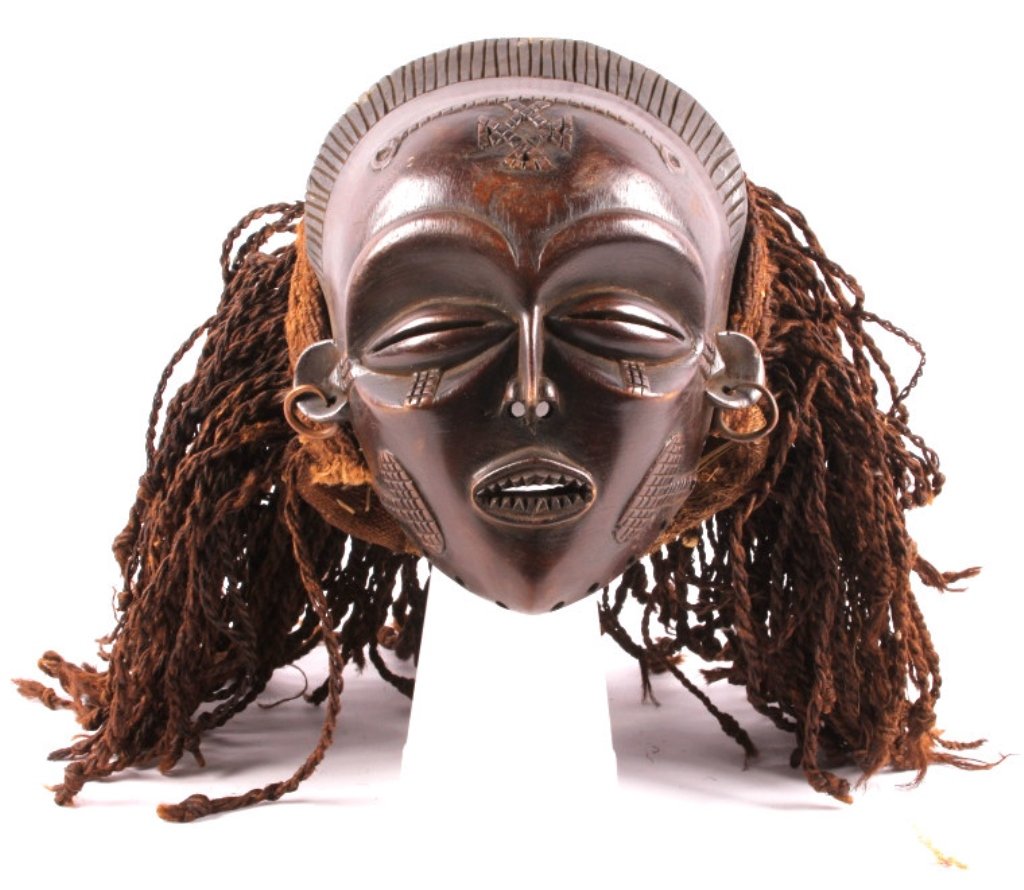 Antique African Dan Mask This lot features an Afri: This lot features an African Dan mask with braided hair. The Pende mask. It is hand carved and in good condition. The mask shows brass trade earrings. The mask has impressive carvings showing excellet