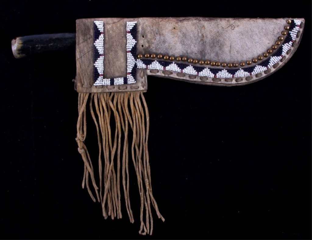 Blackfoot Beaded Scabbard & Knife The lot features: The lot features a Buffalo rawhide scabbard showing trade brass washed iron tacks and is framed with beadwork. This is from a Blackfeet Native American Indian and is believed to be a very early piece,