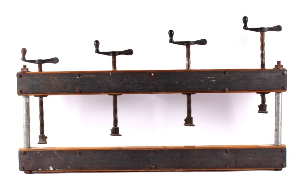 Antique Primitive Press This lot features an antiq: This lot features an antique primitive press. This press is equipped with 4 screw down clamps supported by a sturdy wood and steel frame. The press is in very good condition. It measures 15" x 40".